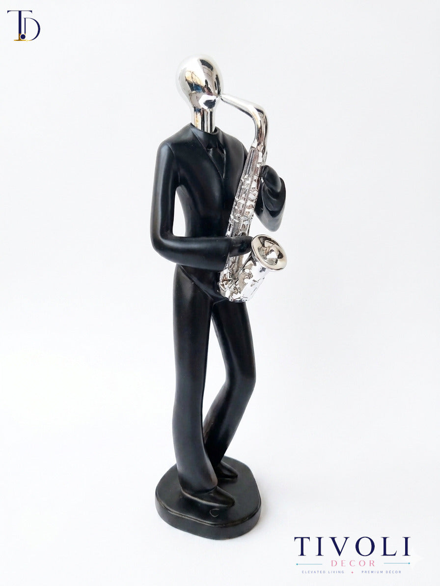 Modern matte black and chrome silver saxophone player statue by Tivoli Decor, a premium abstract music decoration piece for living room console tables in Pakistan.