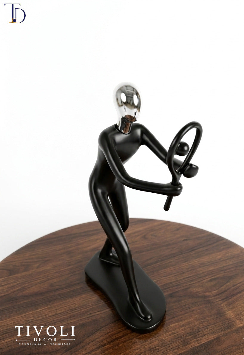 Modern matte black and chrome silver tennis player statue with racket by Tivoli Decor, a premium abstract sports decoration piece on a dark wood table in Pakistan.
