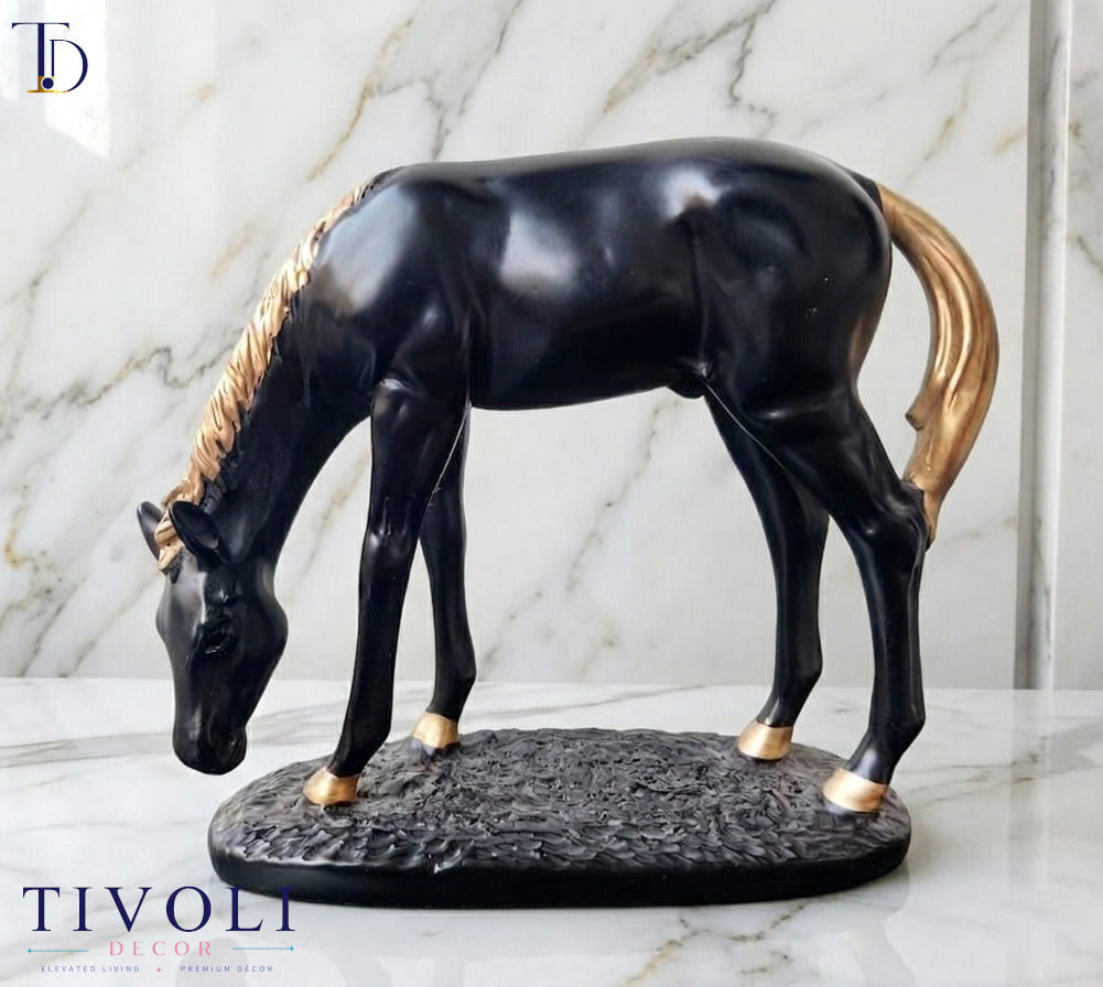 Modern matte black grazing horse statue with golden mane and tail by Tivoli Decor, a premium abstract decoration piece displayed on a white marble surface in Pakistan.