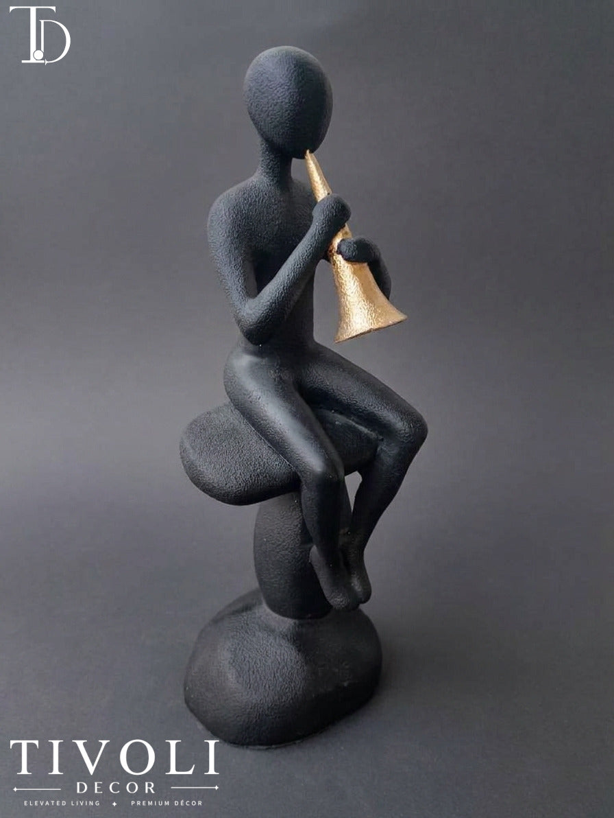 Modern volcanic black musician statue with a golden trumpet by Tivoli Decor, a premium abstract decoration piece for living room console tables in Pakistan.