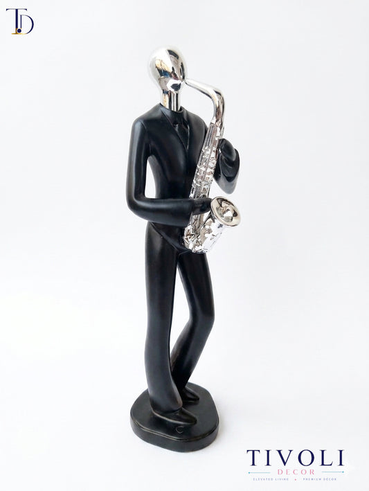 Modern matte black and chrome silver saxophone player statue by Tivoli Decor, a premium abstract music decoration piece for living room console tables in Pakistan.