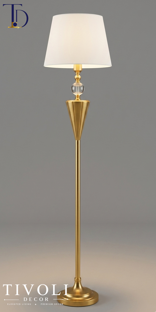Branded Tivoli Decor luxury gilded chalice floor lamp with a fluted gold stem, clear crystal sphere accent, and tapered ivory shade against a grey background.