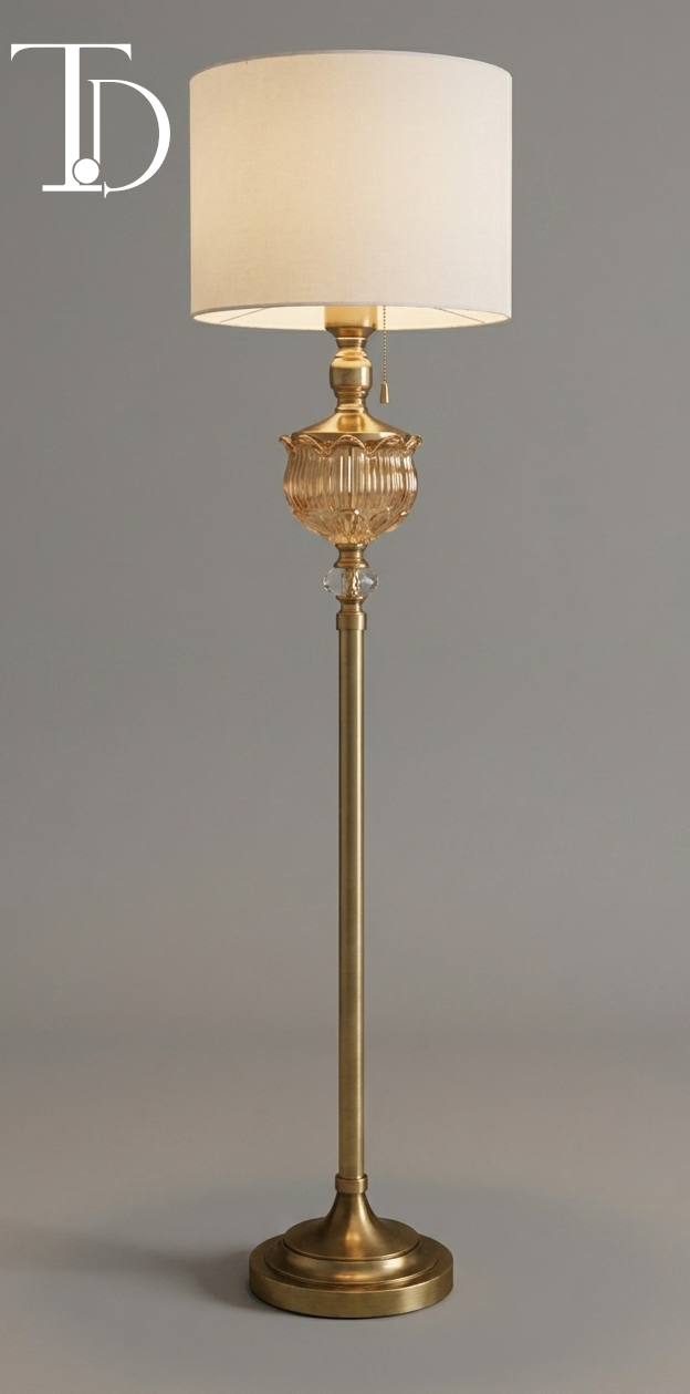 Branded Tivoli Decor imperial gold floor lamp with a fluted amber glass center accent, classic pull chain, and cream fabric shade against a grey background.
