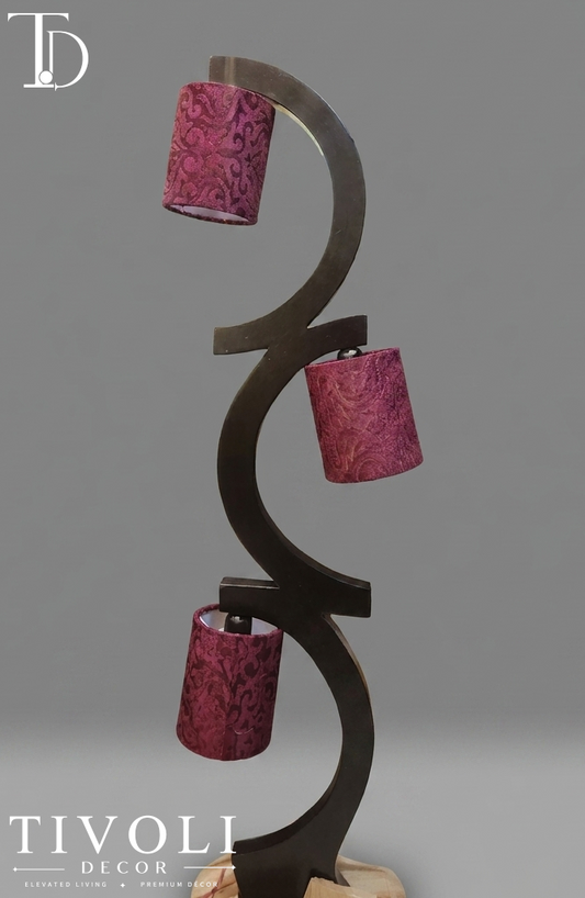 Branded Tivoli Decor trinity sculptural wooden multi light floor lamp with a dark interlocking wave frame and three maroon damask patterned fabric shades.