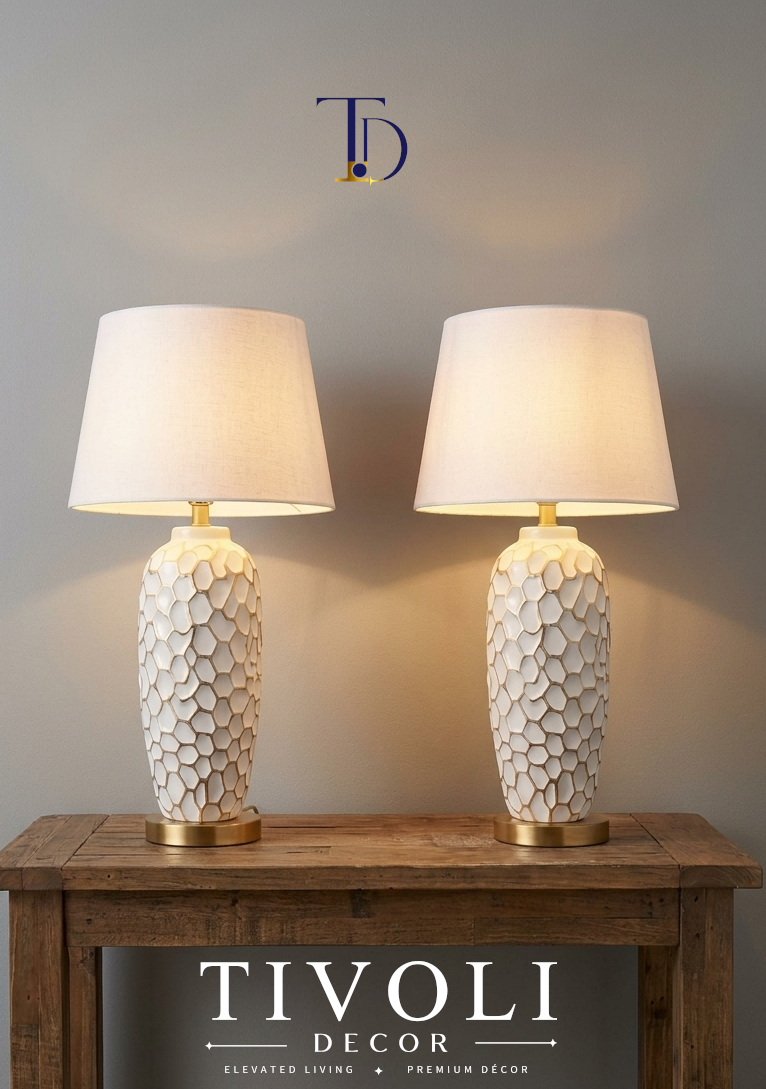 Pair of Tivoli Decor luxury textured white ceramic table lamps with cream fabric shades lit symmetrically on a wooden console table.