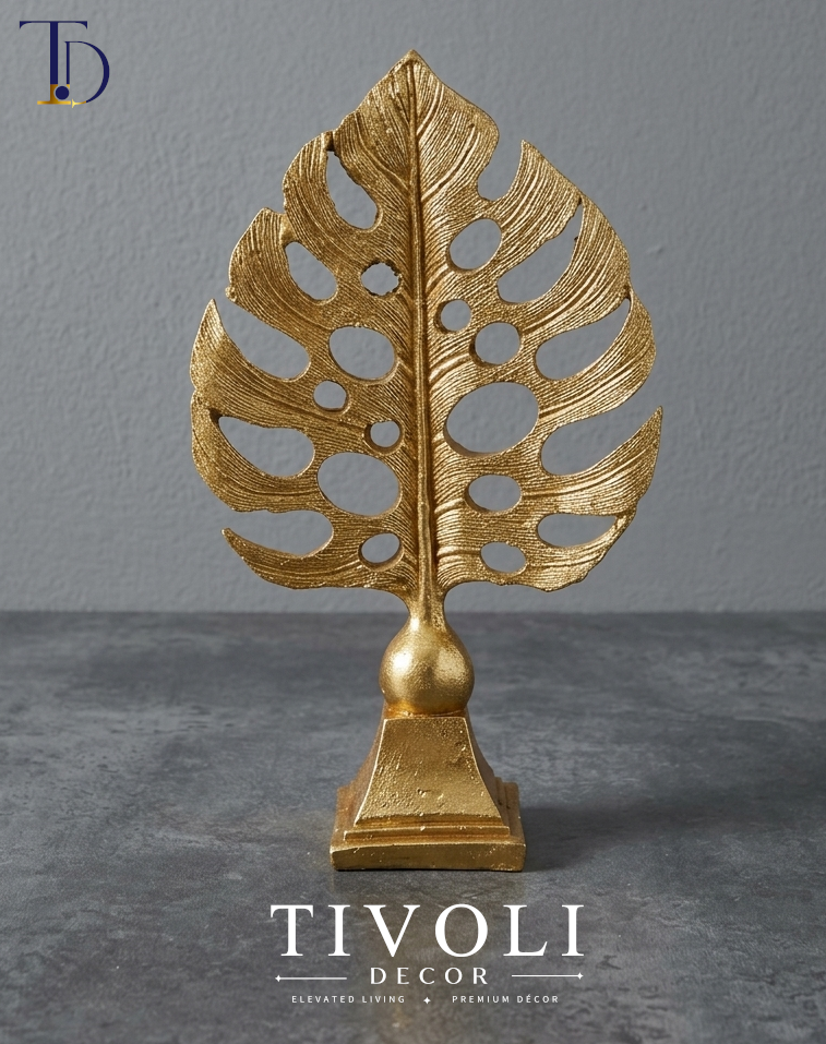 Luxury metallic golden monstera leaf tabletop statue by Tivoli Decor, a premium abstract botanical decoration piece for living room tables in Pakistan.