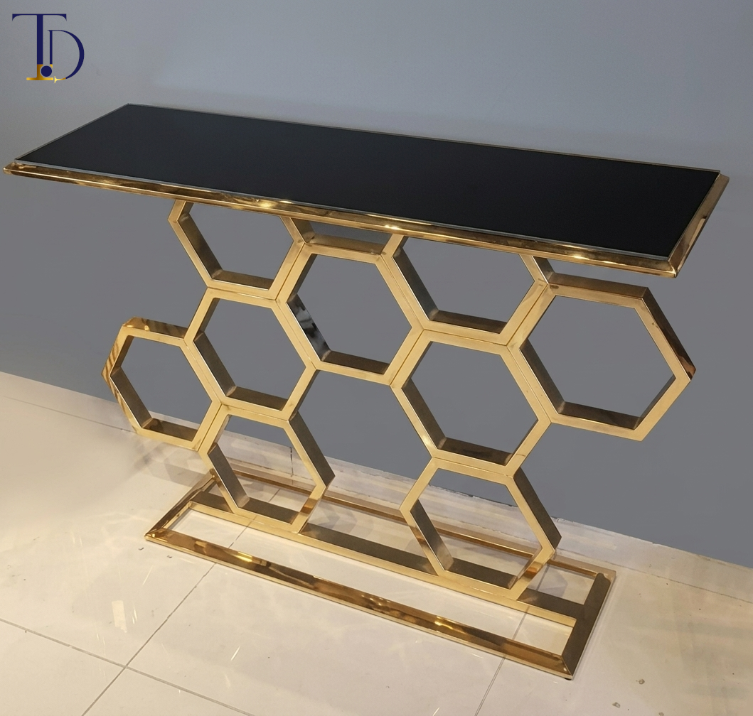 Branded Tivoli Decor luxury honeycomb console table with a sleek black glass top, interlocking gold geometric hexagon base, and stable rectangular baseline.